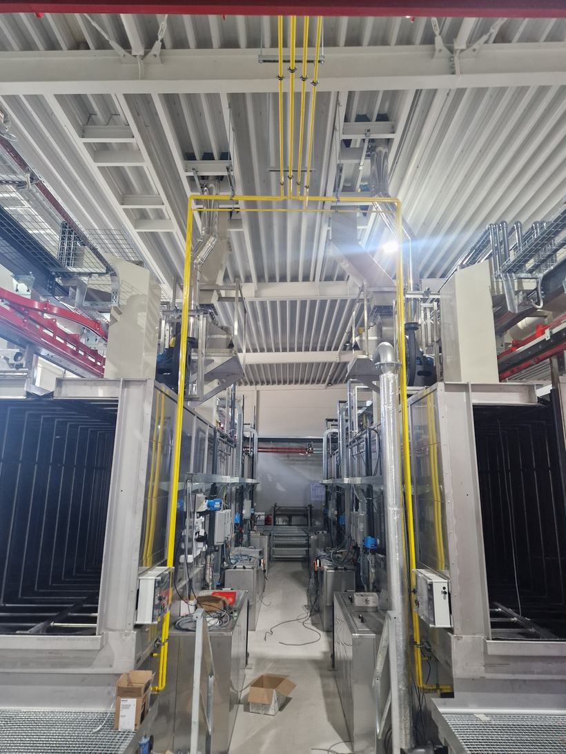 Žlutý plynovod vedený pod stropem výrobní haly k technologii